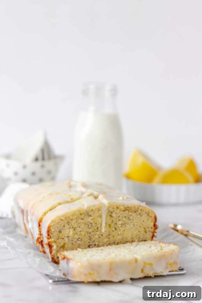 A freshly baked Lemon Poppy Seed Loaf with Glaze, beautifully sliced to reveal its moist texture and delightful poppy seeds. A vibrant, zesty dessert perfect for any occasion.