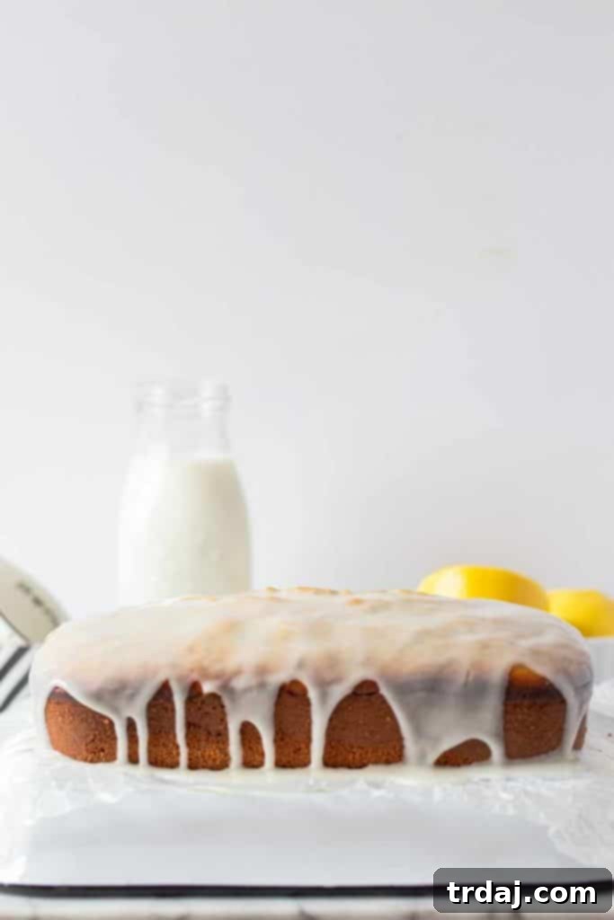 A close-up view of the Lemon Poppy Seed Loaf generously coated with a glistening lemon glaze, showcasing the beautiful drizzle and the cake's inviting texture.