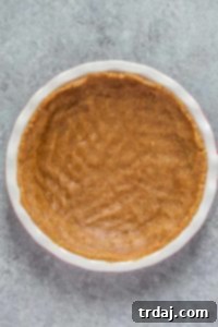 No-bake pecan pie crust pressed evenly into a pie pan, ready for chilling