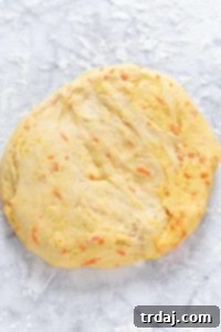 Ball of carrot cake cinnamon roll dough resting in a bowl