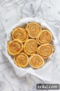 Carrot cake cinnamon rolls arranged in a baking pan, ready for the second proofing