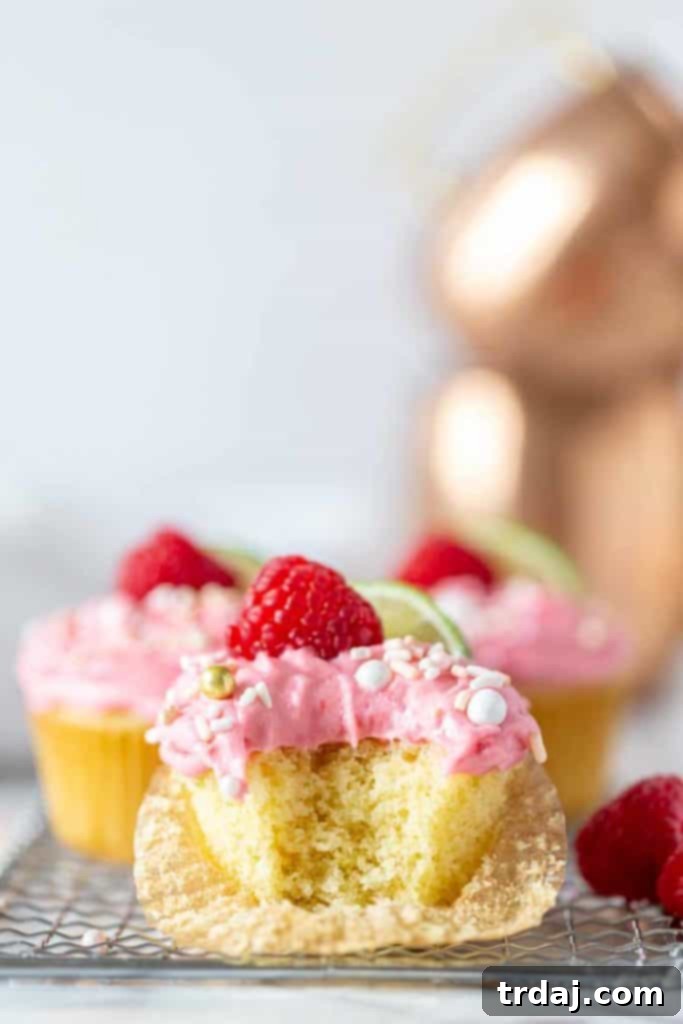 Raspberry Moscow Mule Cupcake with raspberry buttercream with single bite taken.