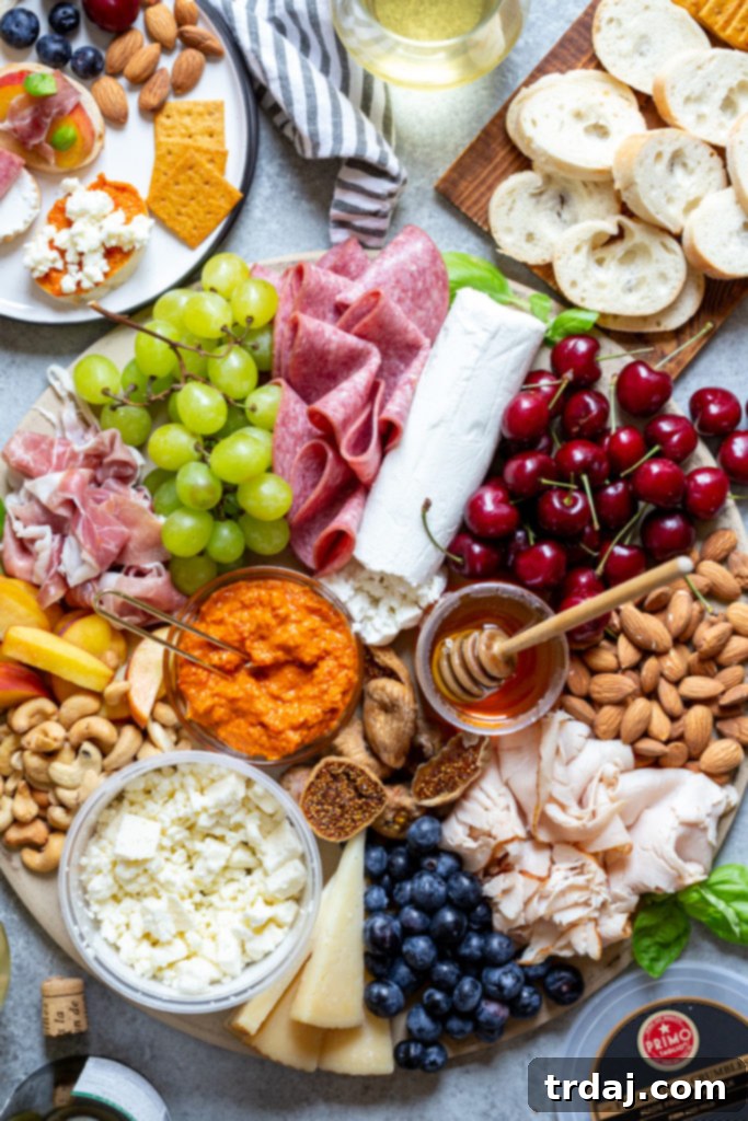 close up shot of meat and cheese board filled with seasonal fruit, nuts, spreads and honey