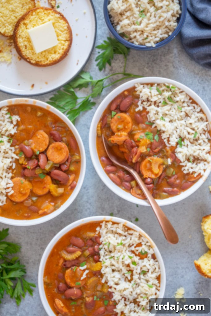 Flavorful and rich, with andouille sausage and hearty vegetables, this One Pan Easy Red Beans and Rice is pure comfort food and on the table in less than 30 minutes! Bowls overflowing with vibrant red beans, perfectly cooked rice, and a side of golden cornbread, creating a truly inviting and comforting meal.