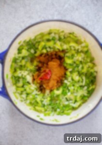 Effortless Red Beans and Rice 3 The aromatic mixture of green bell pepper, onion, celery, and garlic is now combined with rich tomato paste and vibrant Cajun seasoning in the pot, creating a deeply flavored base.