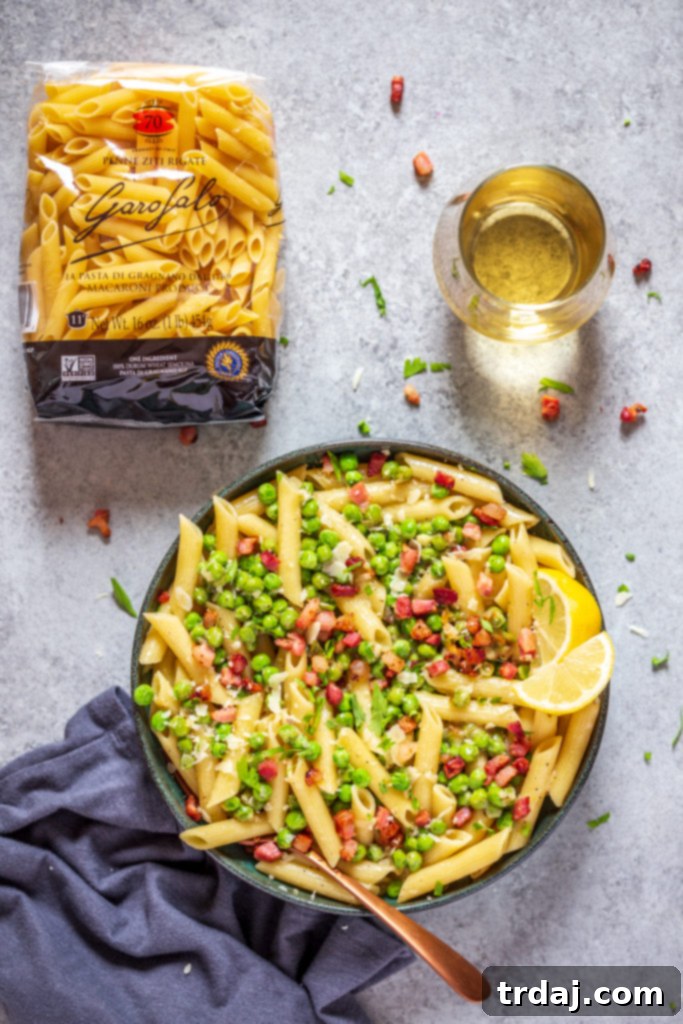 Overhead view of Crispy Pancetta and Sweet Pea Ziti being served in a large bowl.