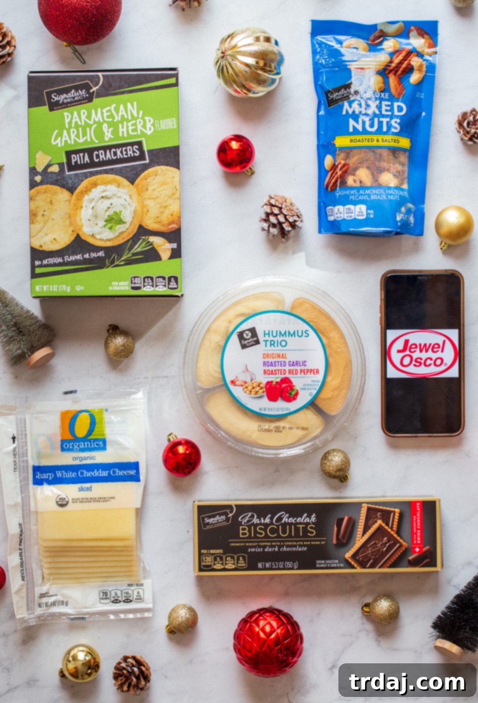 Gift basket filled with snacks like cheese, crackers, and nuts, next to a mini wine bottle