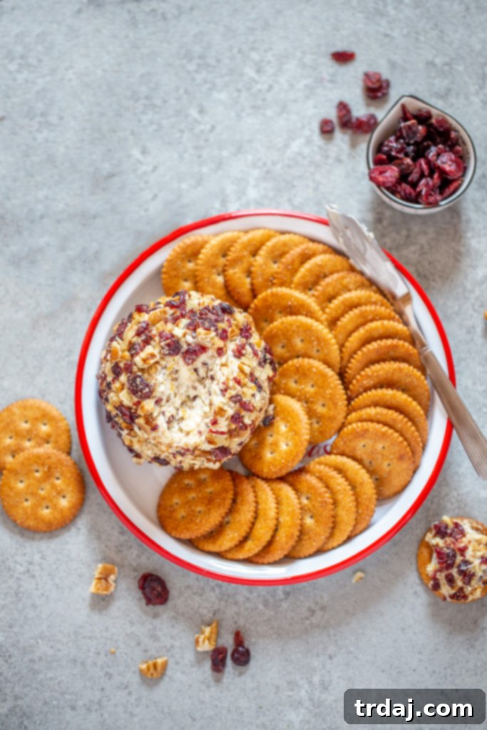 Cranberry Orange Pecan Cheeseball on a platter with crackers