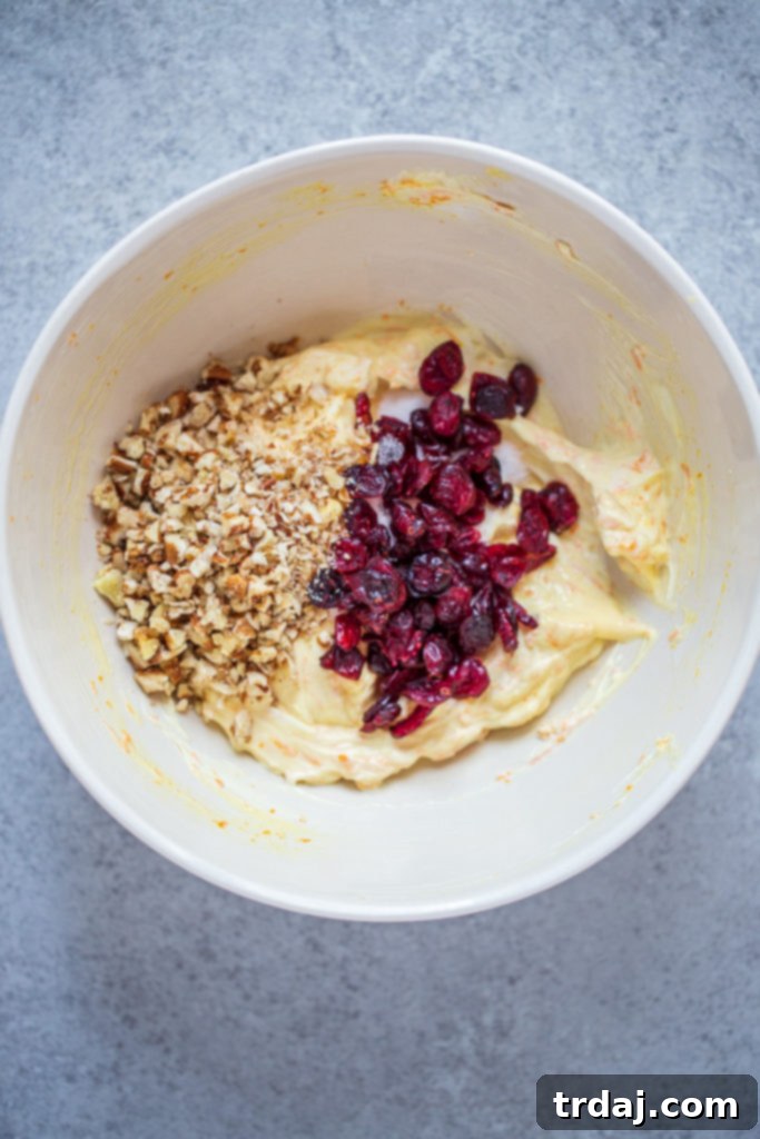 Transfer to a bowl and fold in ¼ cup cranberries and ¼ cup pecans. 