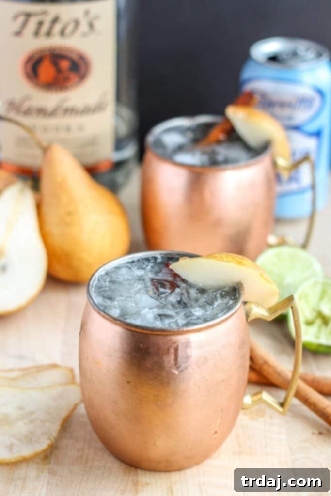 The perfect fall cocktail, this Spiced Pear Moscow Mule features spiced pear simple syrup, vodka, lime and ginger beer. It'll have you enjoying the flavors of Autumn sip after sip. | Strawberry Blondie Kitchen