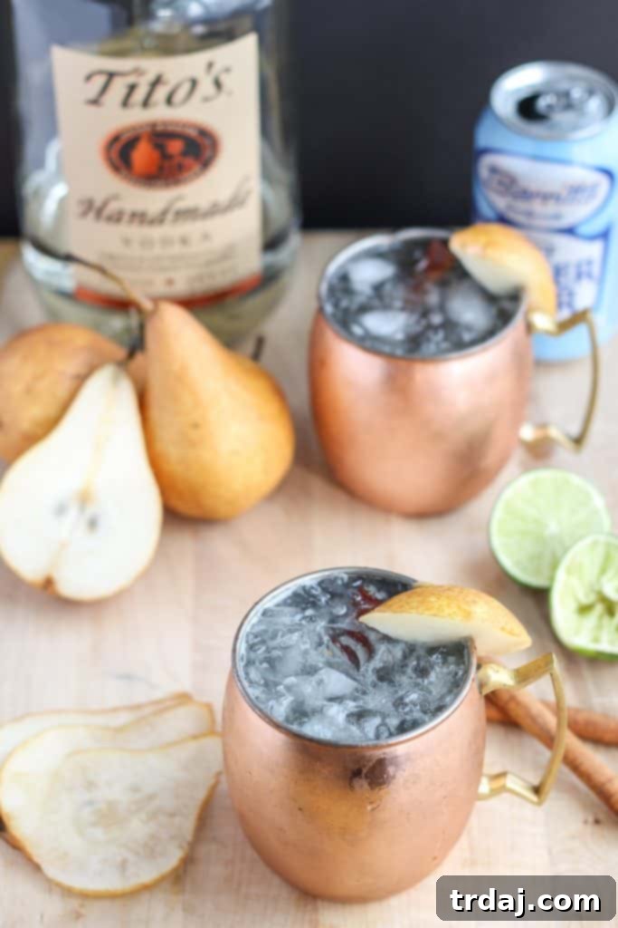 The perfect fall cocktail, this Spiced Pear Moscow Mule features spiced pear simple syrup, vodka, lime and ginger beer. It'll have you enjoying the flavors of Autumn sip after sip. | Strawberry Blondie Kitchen