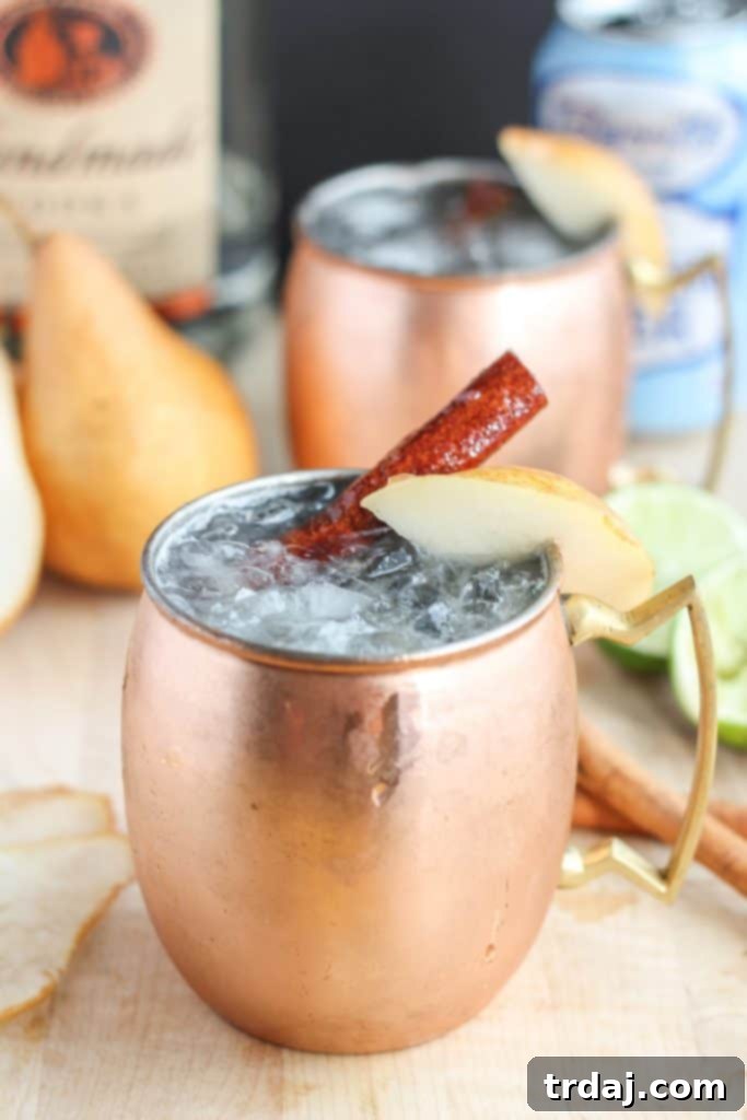 The perfect fall cocktail, this Spiced Pear Moscow Mule features spiced pear simple syrup, vodka, lime and ginger beer. It'll have you enjoying the flavors of Autumn sip after sip. | Strawberry Blondie Kitchen