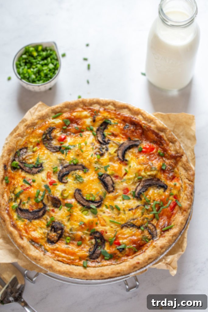 Whole vegetable quiche with bottle of milk and fresh chives, ready to be served for a delicious meal.