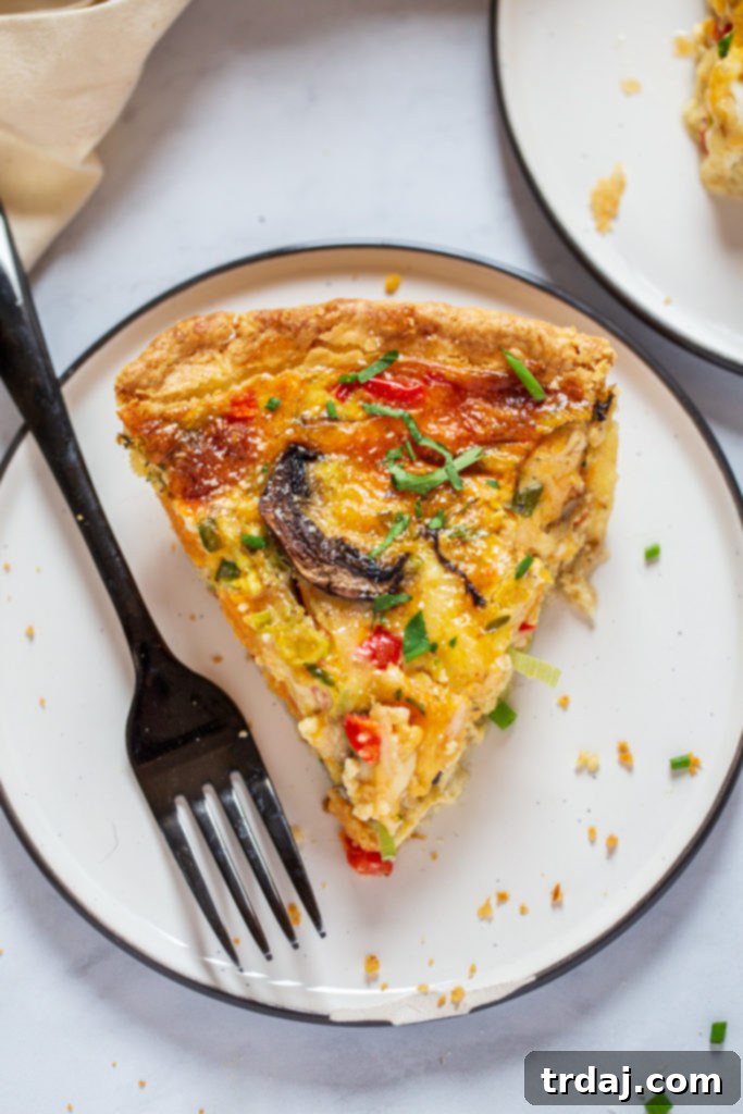 A single slice of easy vegetable quiche perfectly plated, showcasing its golden crust and vibrant filling.