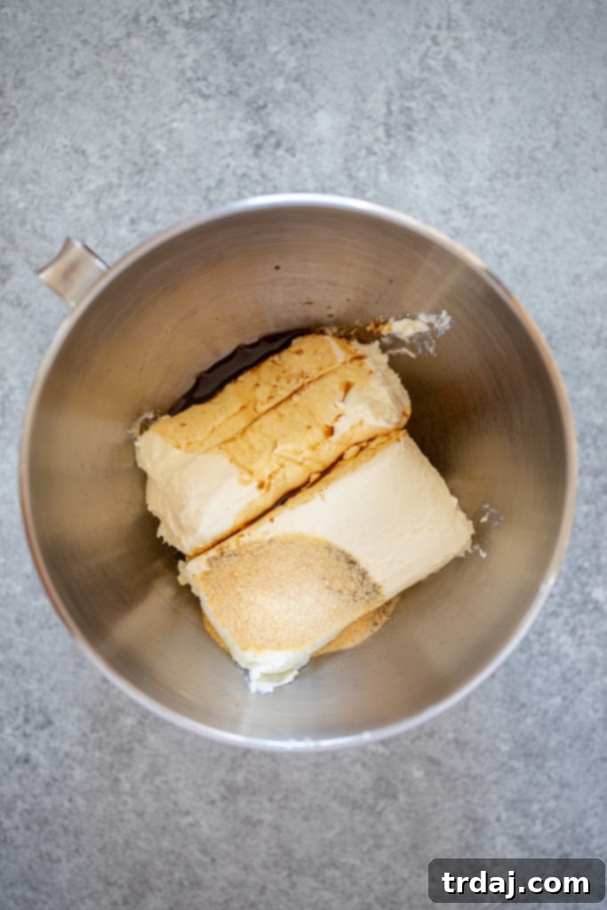 Cream cheese, Worcestershire sauce, and various seasonings are blended in a mixing bowl for the cheese ball base.