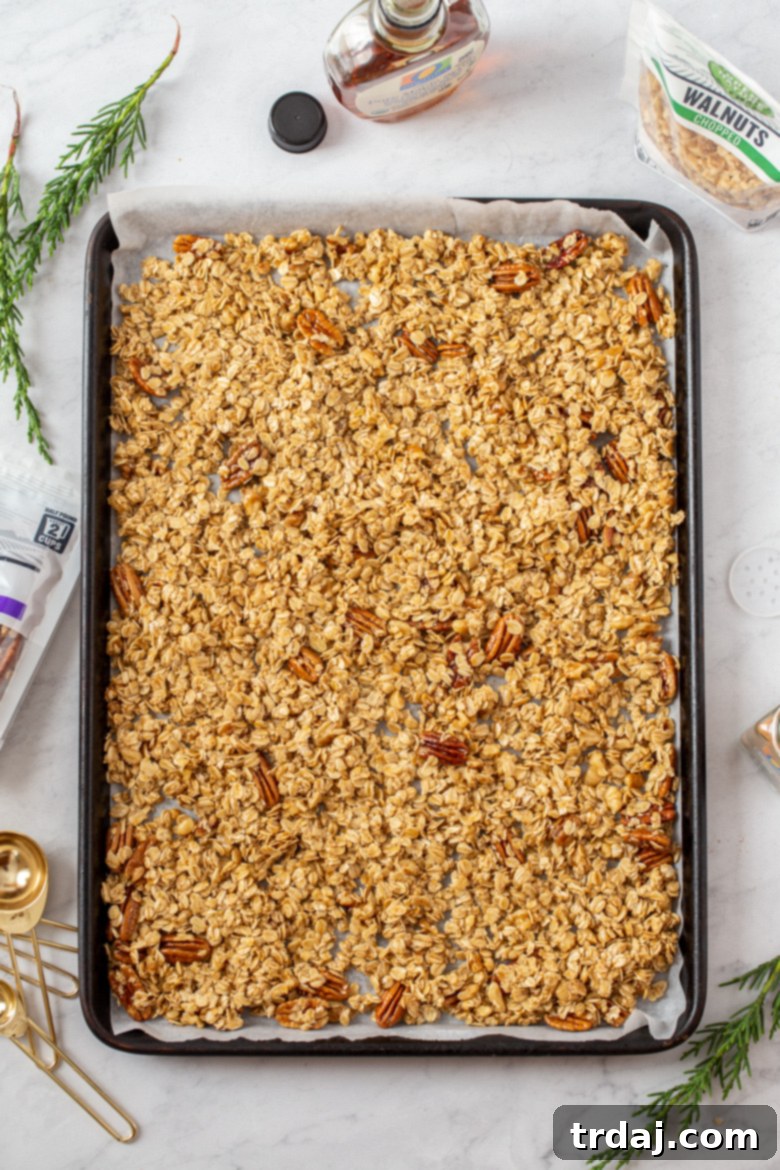 Spreading granola onto a parchment-lined baking sheet for even baking