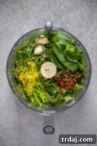 Salsa verde ingredients being processed in a food processor.