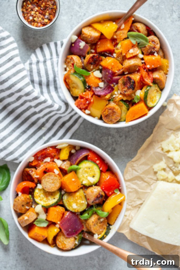 Multiple serving bowls showcasing the delightful Sheet Pan Chicken Sausage and Roasted Vegetables, generously topped with fresh basil and Parmesan cheese, illustrating perfect meal prep portions.