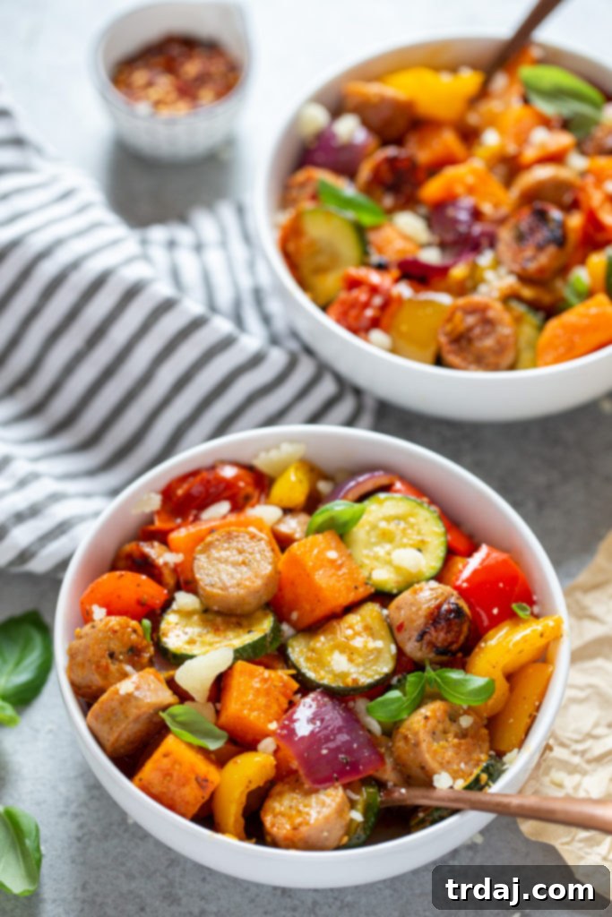 A close-up shot of a single serving bowl brimming with perfectly cooked sheet pan chicken sausages and an appetizing assortment of roasted vegetables, invitingly ready to be enjoyed.