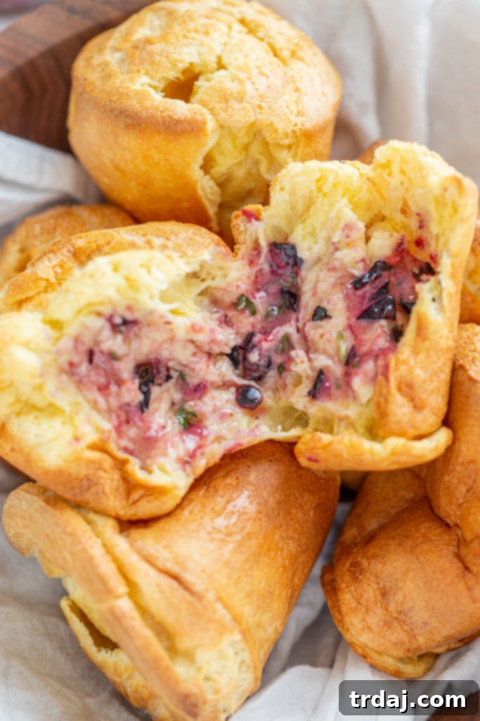 Close-up shot of a warm popover split open and spread with blueberry basil lemon butter, ready to be eaten