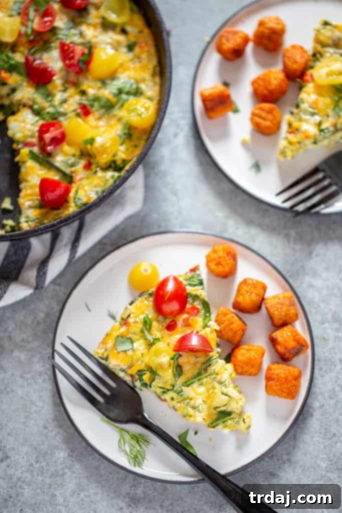 A slice of Garden Herb Frittata on a plate with crispy sweet potato tots