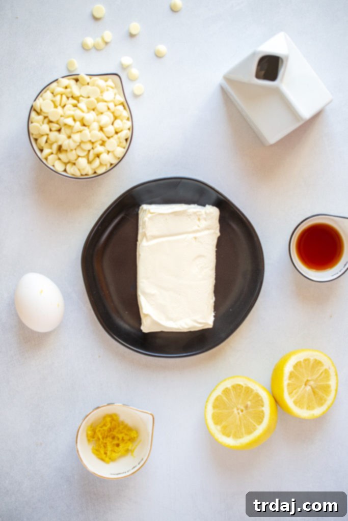 Ingredients for white chocolate lemon cheesecake tart including butter, cream cheese, lemons, and berries