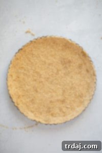 Crust being pressed up the sides of a fluted tart pan