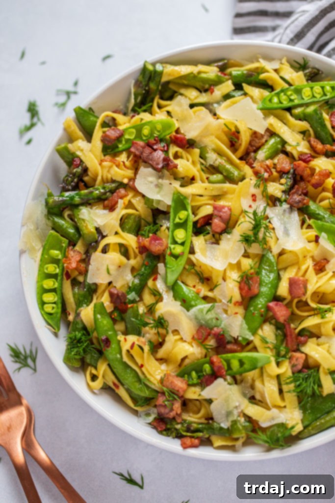 Springtime Lemon Pasta served in a shallow white bowl, garnished with fresh dill and a lemon slice.