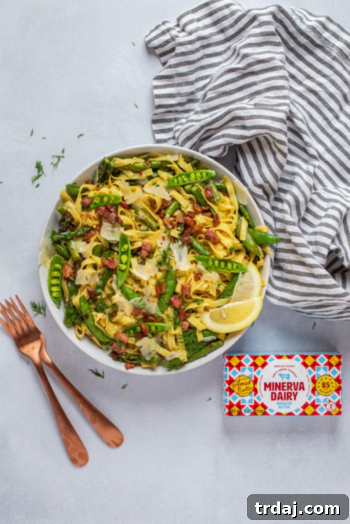 Minerva Dairy butter unwrapped, showcasing its rich yellow color, next to a whisk and a bowl of pasta.