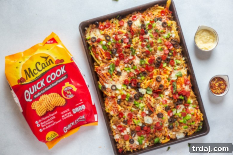 Sheet Pan Supreme Pizza Fries on a wooden board with fresh basil