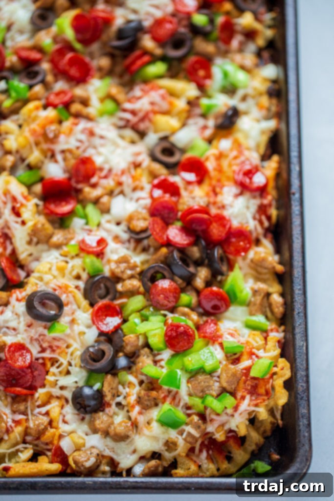 Close-up of Sheet Pan Supreme Pizza Fries with melted cheese and toppings