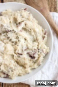 Free up space in your oven this holiday season with these Slow Cooker Goat Cheese Mashed Potatoes. They're tangy and full of garlic flavor from the herb goat cheese, fluffy and irresistibly delicious. They're sure to have your guests going back for seconds! | Strawberry Blondie Kitchen