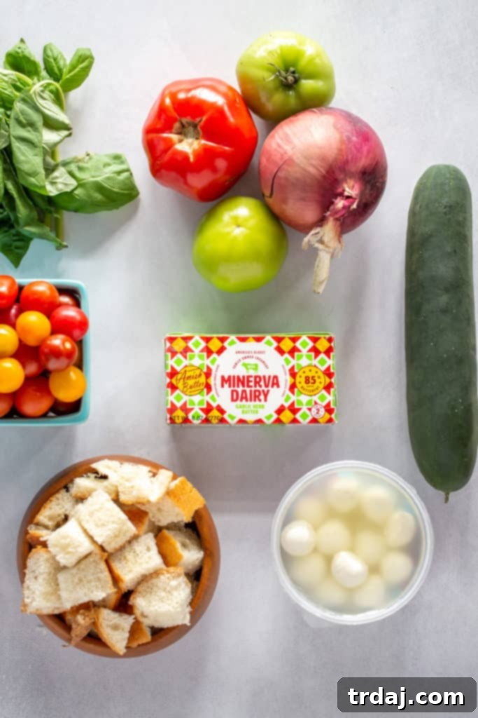 Colorful assortment of panzanella salad ingredients in a bowl before tossing