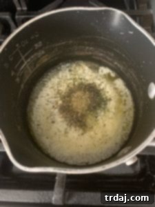 Adding dried herbs to the melted garlic butter mixture