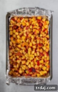 Diced peaches mixed with brown sugar, cinnamon, cardamom, cornstarch, and lemon juice layered on top of the pre-baked crust.