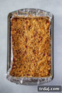 Fully baked pan of peach cobbler crumble bars, golden and ready to cool.