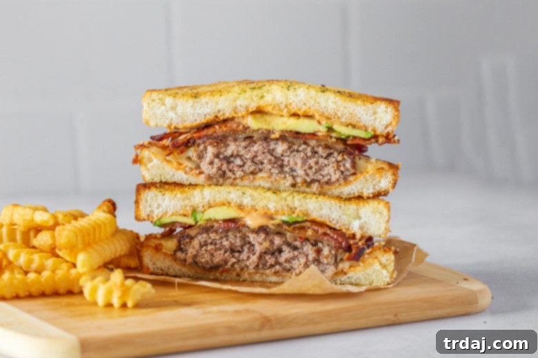 Two fully assembled Southwestern Patty Melts served with French fries