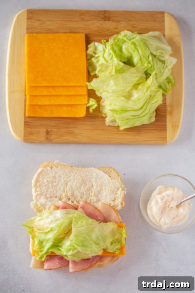 A classic turkey and cheddar cheese sub sandwich on a roll with lettuce, packed for a school lunch.