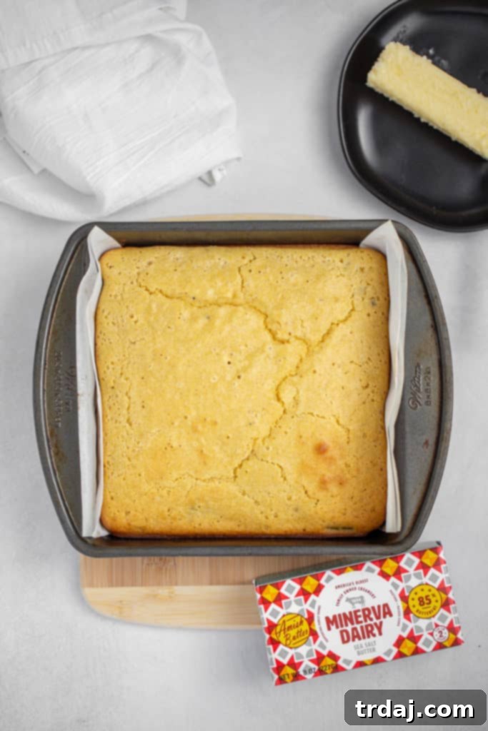 Golden Brown Roasted Green Chile Cornbread A golden brown pan of roasted green chile cornbread, freshly baked and taken out of the oven, showing a perfectly crispy top.