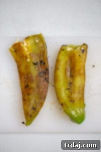 Peeled roasted Anaheim chiles, with their charred skin removed, revealing the soft, green flesh.