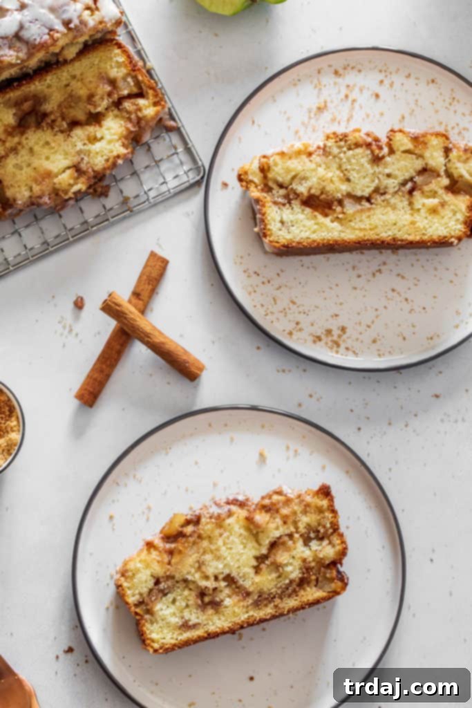Slices of apple fritter bread on plates, showcasing its moist texture, apple chunks, and cinnamon swirl
