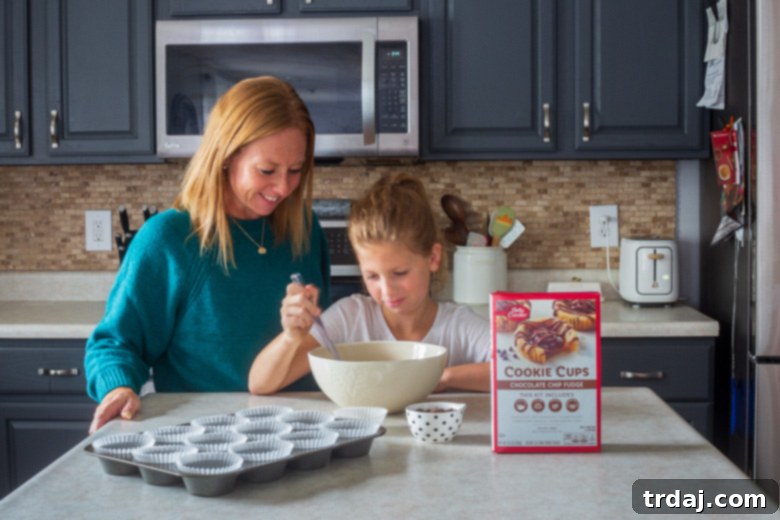 A heartwarming scene of a mother and daughter baking Betty Crocker™ Cookie Cups together in the kitchen, a true 'Mommy and Me' baking moment.