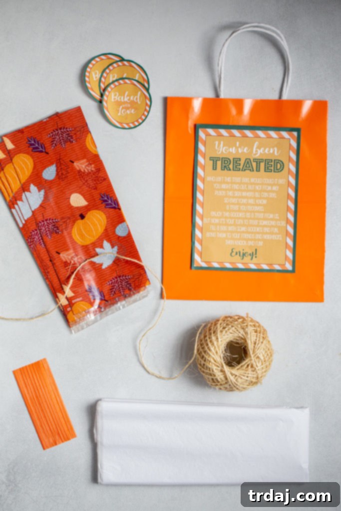 An organized collection of supplies needed for assembling 'You've Been Treated' goodie bags, including bags, ribbons, and baking cups.