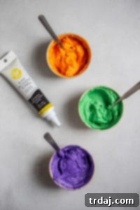 Assorted Halloween candy and food coloring options for decorating cupcakes.