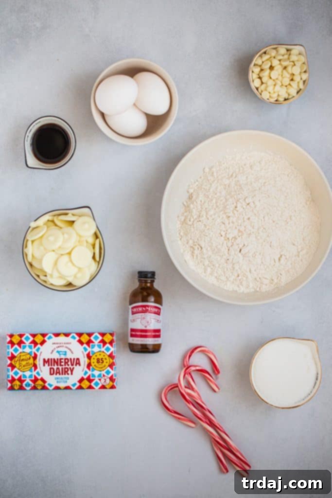Ingredients for homemade Peppermint Blondies Assortment of ingredients laid out, including white chocolate, butter, sugar, eggs, extracts, flour, and candy canes, ready for making Peppermint Blondies