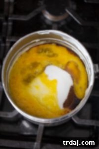 Minty Blondie Bars 3 Wet ingredients for blondies, including sugar, eggs, vanilla, and peppermint extract, being whisked together