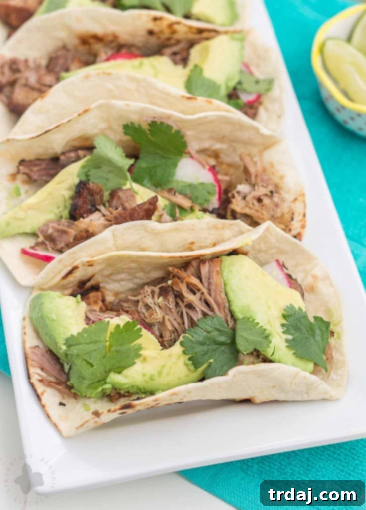 Close-up of shredded Slow Cooker Spicy Pork Carnitas in a bowl, showcasing the tender and juicy texture, ideal for a warm winter game day meal.