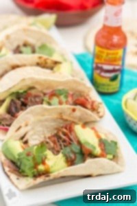 Tender, spicy, moist and juicy these Slow Cooker Spicy Pork Carnitas are perfect for the BIG GAME! Place on top of a tortilla with fresh ingredients, piled high on nachos or sandwiched between bread, no matter how you serve them, you've got a crowd pleaser perfect for game day, dinner or a fiesta! | Strawberry Blondie Kitchen