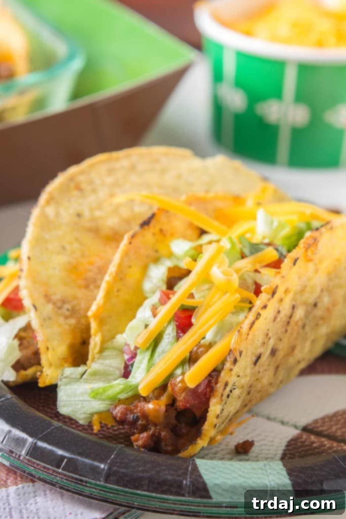 Preparing healthier oven baked tacos for a crowd, showing crispy shells filled with lean ground turkey and cheese.