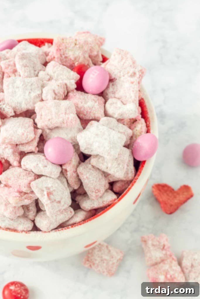 Heart-shaped freeze-dried strawberry detail amongst Strawberry Puppy Chow, emphasizing the romantic theme